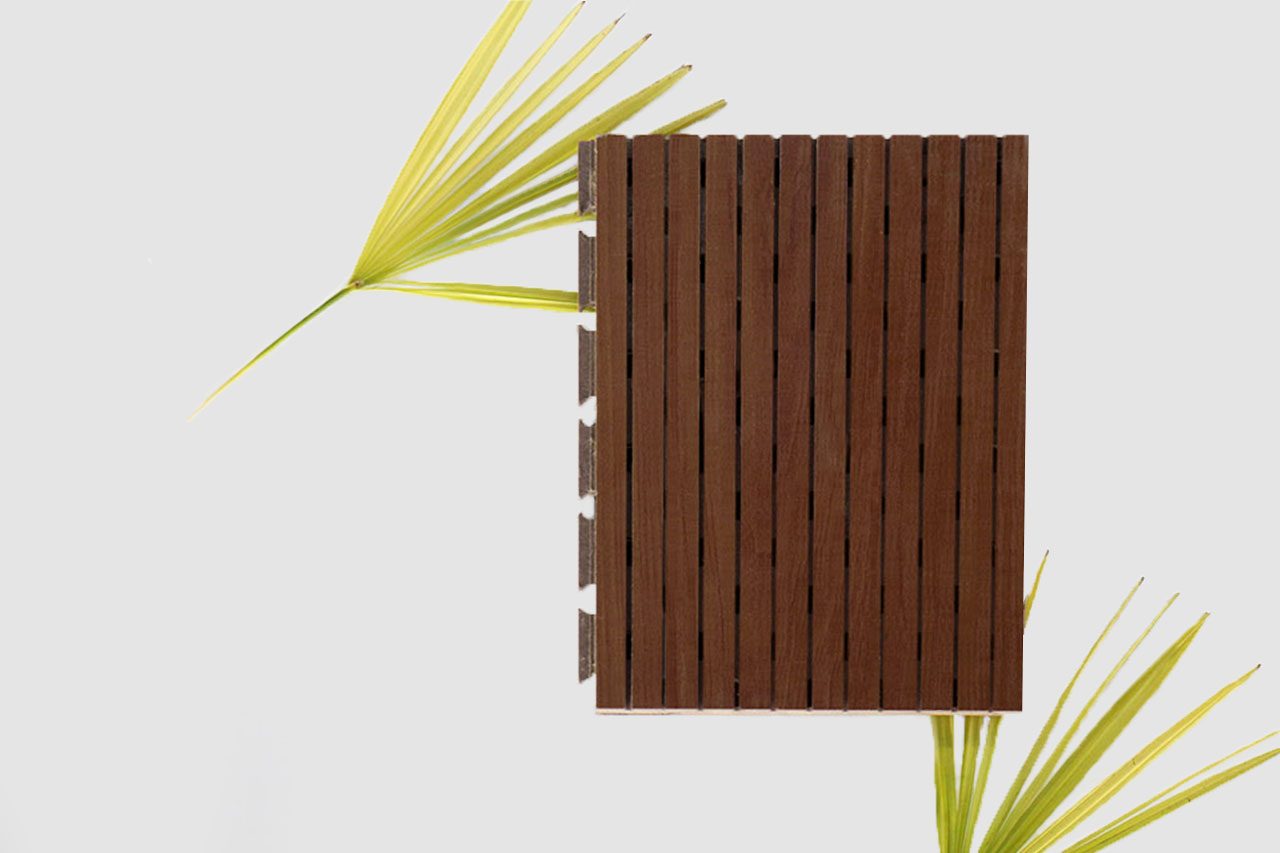 A rectangular brown Timberix Microgrooved Panel is placed vertically on a light gray background, with two green palm leaves partially visible on the left and bottom right sides.