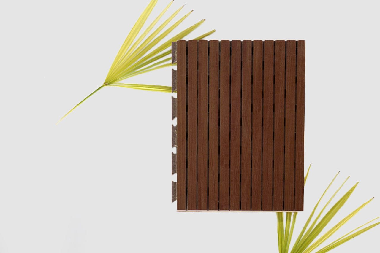 A rectangular brown Timberix Microgrooved Panel is placed vertically on a light gray background, with two green palm leaves partially visible on the left and bottom right sides.